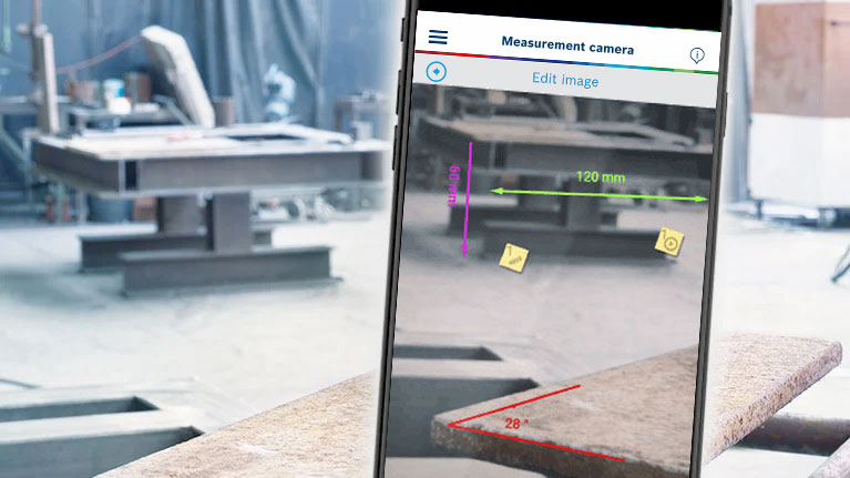 A smartphone displays a measurement camera function in the workshop area.