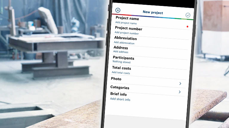 A smartphone displays a project list in a workshop environment.