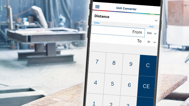 A smartphone displays a unit converter in a workshop.