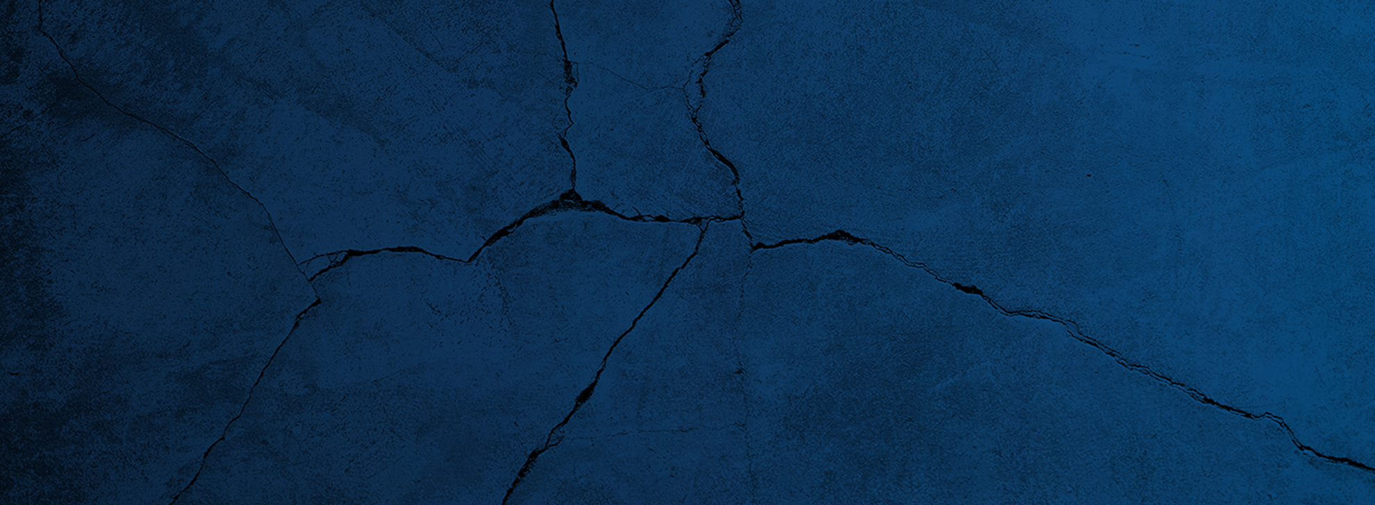 Dark blue wall with cracks running irregularly across the surface.