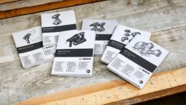 Six user manuals from Bosch Professional are placed on a wooden surface, featuring clear graphics.