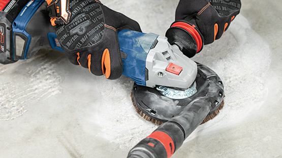 A Bosch Professional angle grinder is being used on a concrete floor.