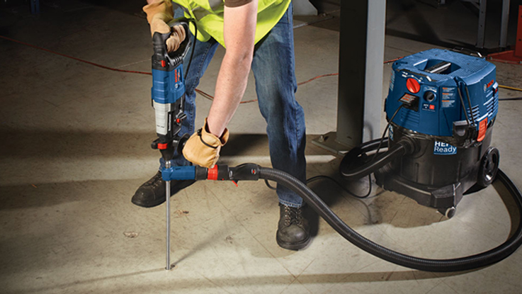 A Bosch Professional rotary hammer is being used by a person.