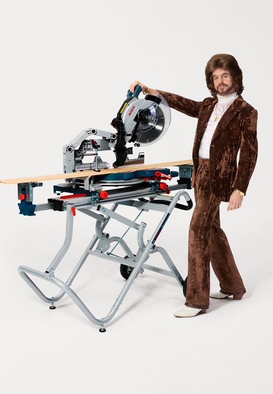 Un hombre con un traje marrón está junto a una sierra ingletadora Bosch.