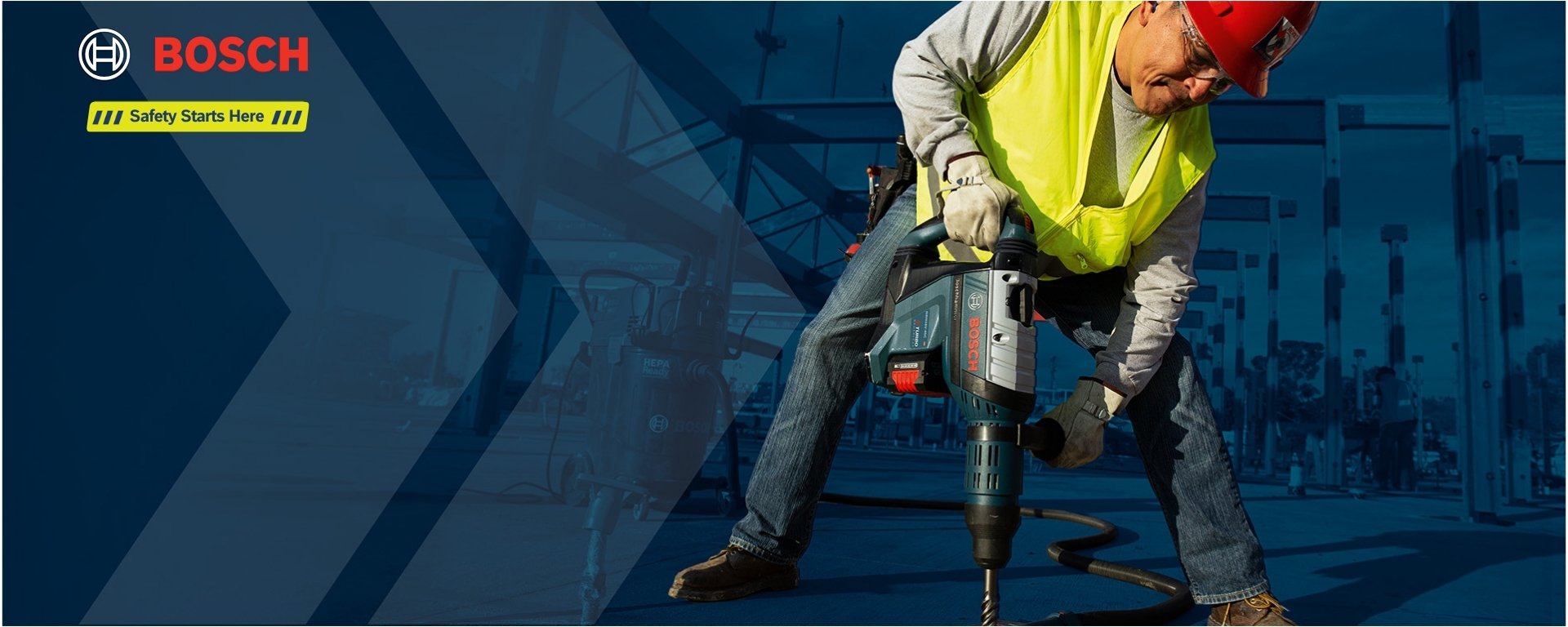 A man in a yellow warning vest and a red helmet is operating a Bosch Professional drill. He stands on a construction site with a blue background and visible tools.