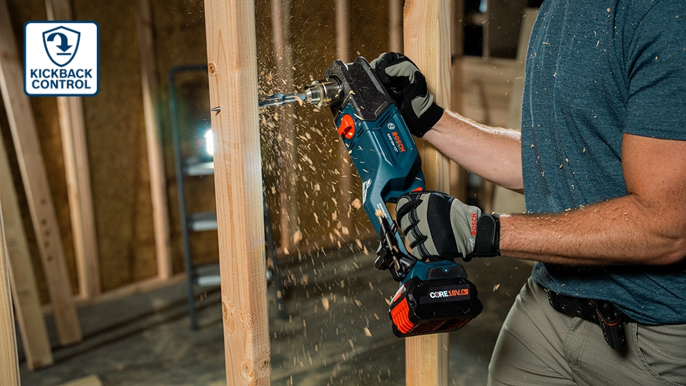A Bosch Professional cordless drill is being used by a person in a wooden frame, wood shavings are flying.
