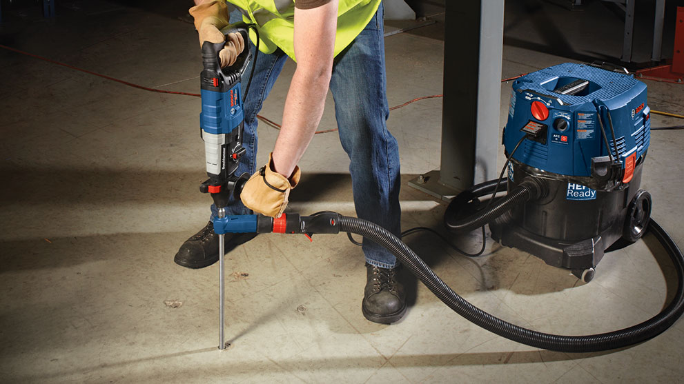 A worker with Bosch Professional tools is drilling on a floor.
