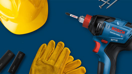 A blue Bosch Professional cordless drill next to yellow gloves and a helmet.