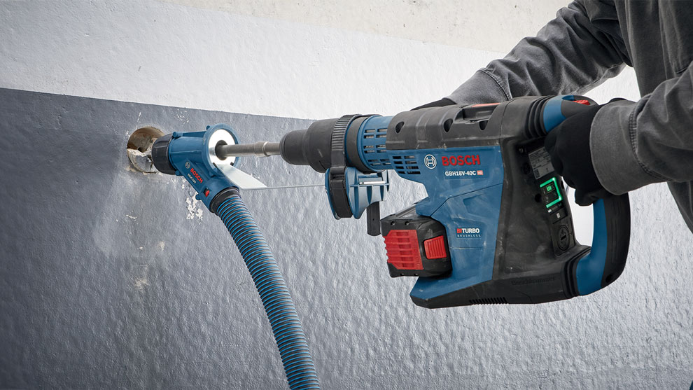A Bosch Professional hammer drill is being used on a wall.